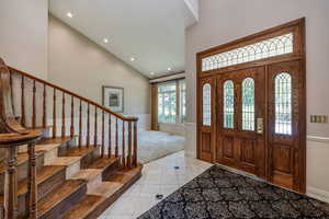 Entryway foyer with high vaulted ceiling and light marble tile flooring.  Formal living room on one side and Formal dining on the other.