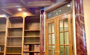 Office with up-close shelving, french door and leaded glass features.