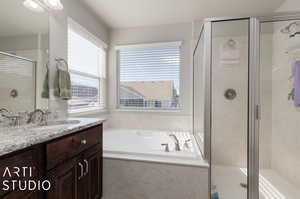 Bathroom with plenty of natural light, shower with separate bathtub, and vanity