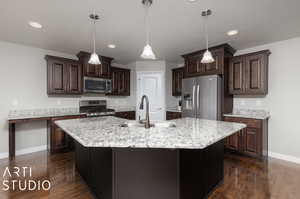 Kitchen with an island with sink, stainless steel appliances, sink