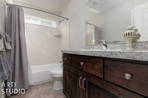 Full bathroom featuring tile flooring, shower / bath combination with curtain, vanity, and toilet