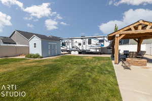 View of yard featuring a patio area, a fire pit, and a shed