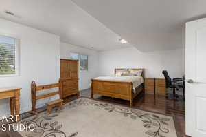 Bedroom with dark flooring and multiple windows