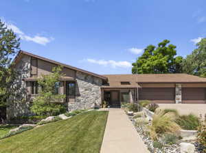 View of front of home with a front lawn and a garage