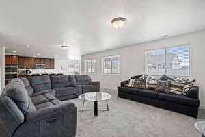 Living room with a textured ceiling and carpet