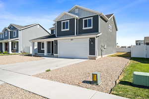 View of front of home featuring a garage and central air condition unit