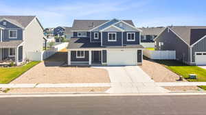 View of front facade featuring a garage and a front lawn