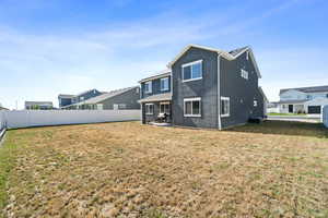 Back of property with a yard and central air condition unit