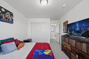 Bedroom with a closet and light colored carpet