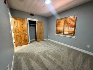 Unfurnished bedroom featuring carpet and a closet