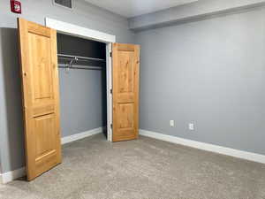 Unfurnished bedroom featuring a closet and carpet flooring