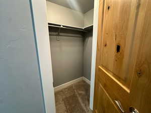 Walk in closet featuring dark colored carpet