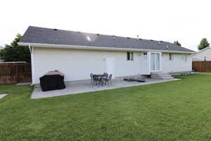 Back of house with a yard and a patio area