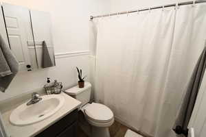 Bathroom featuring vanity, toilet, and tile floors