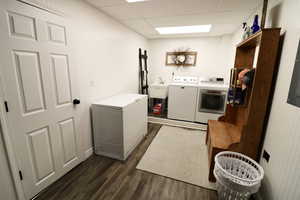 Washroom featuring sink, dark hardwood / wood-style floors, and washing machine and clothes dryer