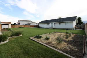 Rear view of house featuring an outdoor structure and a lawn