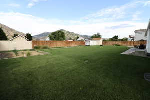 View of yard featuring a patio, a storage shed, and a mountain view