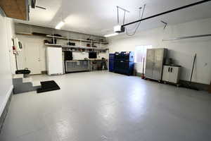 Garage with a garage door opener and white fridge