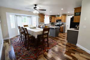 Dining area featuring sink, dark wood-type flooring, and ceiling fan