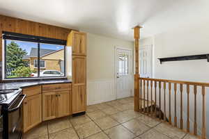 Kitchen with light tile floors and range with electric stovetop