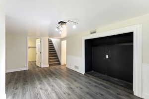 Interior space featuring dark hardwood / wood-style flooring and rail lighting