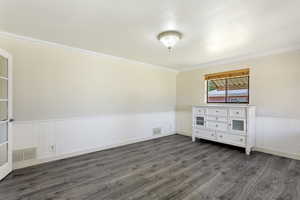 Unfurnished bedroom featuring ornamental molding and dark hardwood / wood-style floors