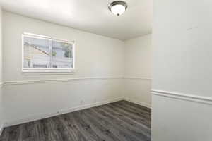 Empty room featuring dark hardwood / wood-style floors