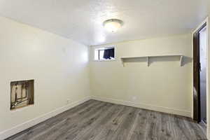 Basement with dark hardwood / wood-style floors and a textured ceiling