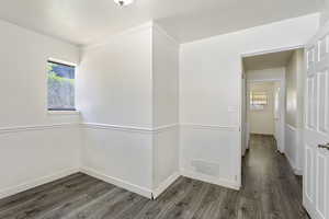 Hallway featuring a wealth of natural light and dark hardwood / wood-style flooring