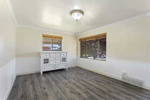 Unfurnished bedroom featuring ornamental molding and dark hardwood / wood-style floors