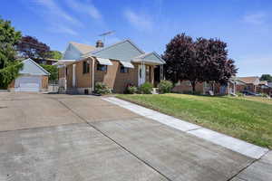 View of front of property featuring an outdoor structure, a garage, and a front yard