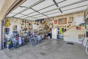 Garage with white refrigerator, a workshop area, and a garage door opener