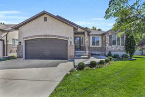 View of front of property featuring a garage and a front yard