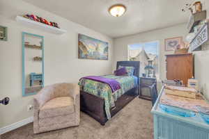 Bedroom with carpet and a textured ceiling