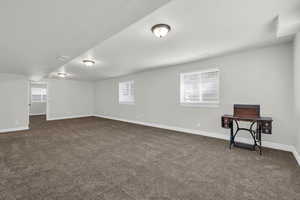 Basement featuring a healthy amount of sunlight and dark colored carpet