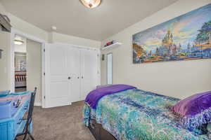 Carpeted bedroom with a textured ceiling and a closet