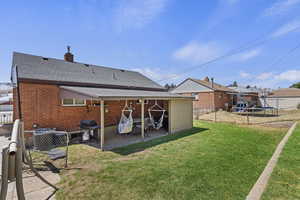 Rear view of house with a patio area, a lawn, and a trampoline