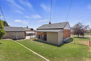 Rear view of property featuring a patio area and a lawn