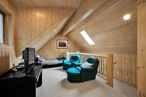 Interior space featuring wood walls, lofted ceiling with skylight, and wood ceiling