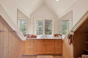 Bathroom featuring tile flooring, lofted ceiling, and vanity