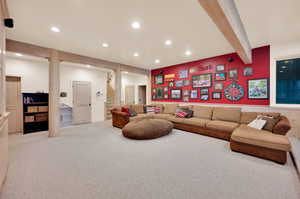 Carpeted living room featuring beam ceiling