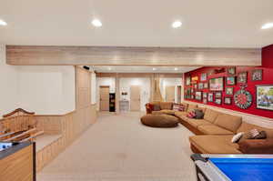 Carpeted living room with beamed ceiling