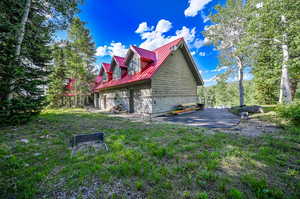 View of property exterior featuring a yard and a patio