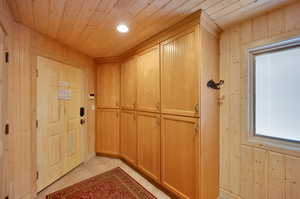 Interior space featuring wood walls, wood ceiling, and light tile floors