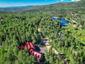 Drone / aerial view featuring a water and mountain view