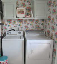 Washroom with hookup for a washing machine, washer and clothes dryer, and cabinets