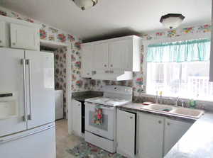 Kitchen featuring white cabinetry, custom range hood, white appliances, sink, and vaulted ceiling