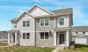 View of front of property with a front yard, an outdoor structure, and a garage