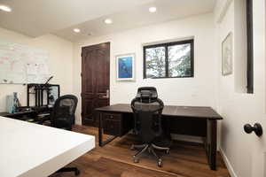 Office with dark wood-type flooring