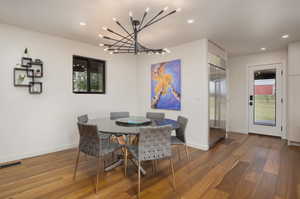 Dining space featuring a notable chandelier and hardwood / wood-style flooring